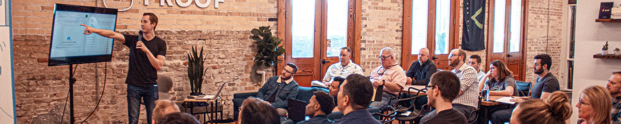 Man presenting power point to small audience in start-up office