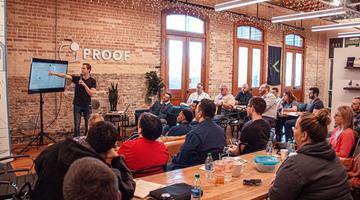 Man presenting power point to small audience in start-up office